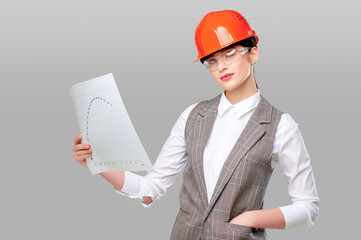 Woman engineer in protective orange helmet wearing glasses holding graph studio on gray isolated background