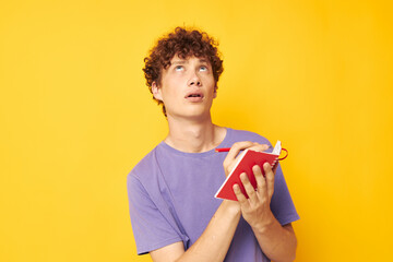 portrait of a young curly man notepad with pen learning emotions isolated background unaltered