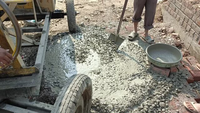 Concrete is being prepared and dropped on the ground with a concrete mixer machine. Concrete Mixer Work on Construction Sites and Knead Concrete. Close Up working cement mixer.