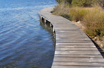 wooden footbridge over water at the shore of a lake