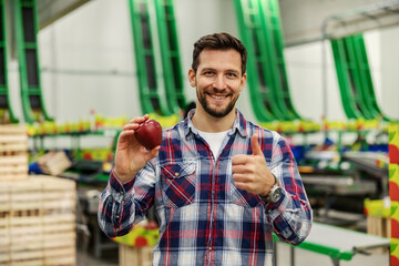 A factory worker with apple approves quality.