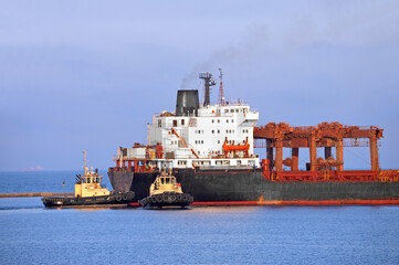 Tugboat assisting general cargo ship