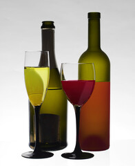 Two glasses of white and red wine and two bottles. 
