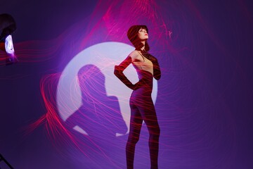 Beautiful fashionable girl posing studio light neon purple background unaltered