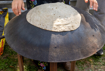 Arabian female person prepare flatbread (other names is pita, lavash, lafa, roti, chapati) on hot...