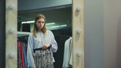 A pretty girl tries on clothes in a clothing store. Shopping