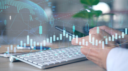 Double exposure of financial graph drawings and a desk with a working notebook in the background. The currency market concept