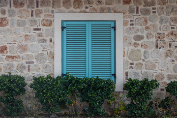 Fototapeta na wymiar Close-up blue wooden vintage window in an old stone house