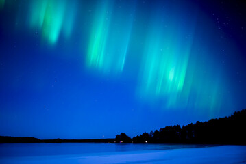 Fototapeta na wymiar Northern lights dancing over frozen lake in Farnebofjarden national park in north of Sweden.
