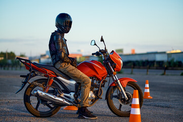 Fototapeta na wymiar Male student poses on motorbike, motorcycle school