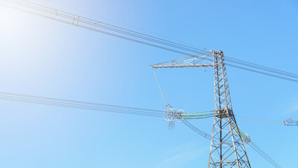 high voltage poles close up against the sky