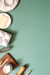 Frame of food ingredients for baking on a green pastel background. Cooking flat lay with copy...
