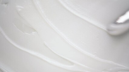 Applying soft moisturizing lotion over white background using shiny metal spatula upper macro view. Antiaging skincare product - Powered by Adobe