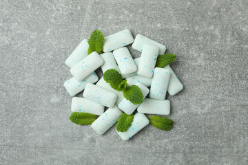 Chewing gum and mint on gray textured background