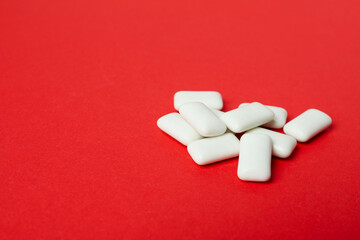 Chewing gum on red background, space for text