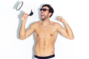 Expressive Caucasian Handsome Brunet Man Shouting With Loudspeaker While Posing in Underware Against White Background.