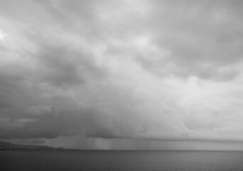 View of rain at Dili from Cristo Rei Statue, Timor Leste. Dramatic stormy dark cloudy sky over sea....