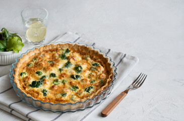 Traditional French pie with cheese and broccoli on a light table. Flan. Copy space.