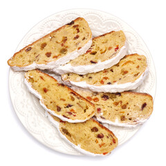 Slices of Traditional Christmas stollen cake with marzipan and dried fruit isolated on white ceramic palte