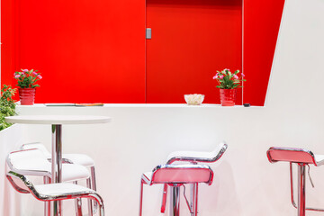 Modern bright red and white room interior with table chairs armchairs