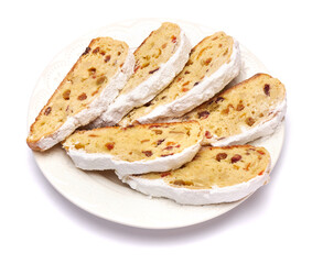 Slices of Traditional Christmas stollen cake with marzipan and dried fruit isolated on white ceramic palte