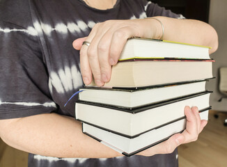 Woman holding a stack of books in her hands