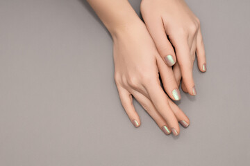 Female hands with pearlescent nail design. Glitter pearlescent nail polish manicure. Female model...