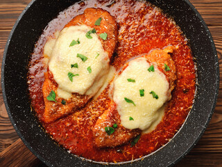 Frying pan with chicken parmigiano top view closeup
