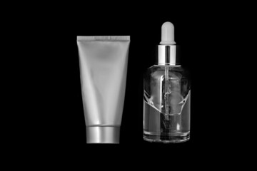 Moisturizer and face serum isolated on black background.