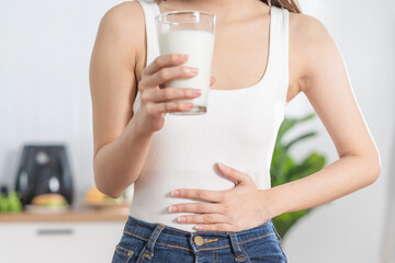 Pain, Allergy asian young woman, girl hand in belly suffer after drink glass of milk, unhappy and bad stomach ache. Lactose intolerance and dairy food , health problem concept.