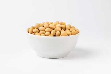 Dry, raw soybean, soy bean in a white bowl isolated on a white background. Popular ingredient of Asian cuisine high protein product soybeans