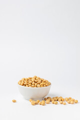 Dry, raw soybean, soy bean in a white bowl isolated on a white background. Popular ingredient of Asian cuisine high protein product soybeans with copy space