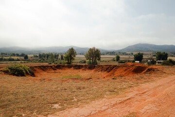 Landscape of Bomb craters field with village and mountains on background in Xieng Khouang Province,...