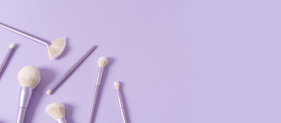 Makeup brushes banner. Set of glamour makeup brushes on a pastel violet background. Magazines, social media. Visagist tools. Top view, copy space. Creative flat lay. Cosmetics products web line, sale