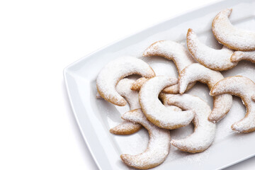 Traditional German or Austrian Vanillekipferl vanilla kipferl cookies on a plate isolated on white background