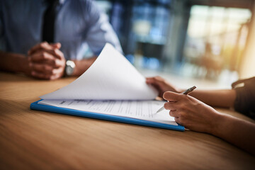 Combing through the fine print. Cropped shot of a man and woman completing paperwork together at a...