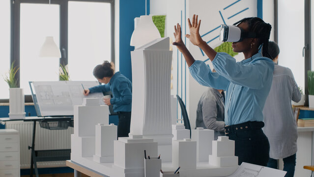 Engineer using vr glasses to design building model and construction for development. Woman architect working with virtual reality goggles to plan urban architecture project in office.