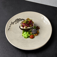 Beef tartare on rye bread with capers, cucumbers, cheese espuma and spices. Meat tartare on handmade ceramic plate. Innovative recipes on modern dishware.