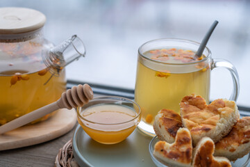 composition with a glass teapot and glass cup filled with tea and cake on the plate