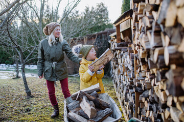 Boy with Down syndrome working in garden in winter with his grandmother.
