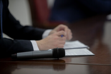 Microphone in seminar room, conference event or press conference Abstract blurred background. News conference. Political debate during answering media questions.