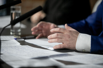 Businessman or politician giving inteview. Close up view gesticulating hands of business man.