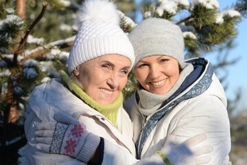 Obraz premium happy woman with mother in winter clothes posing outdoors