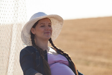 Fototapeta premium pregnant woman in a wheat field