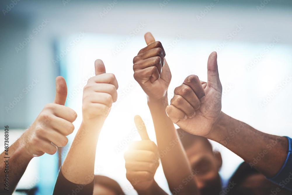 Poster keep up the amazing work. cropped shot of a team of colleagues showing thumbs up at work.