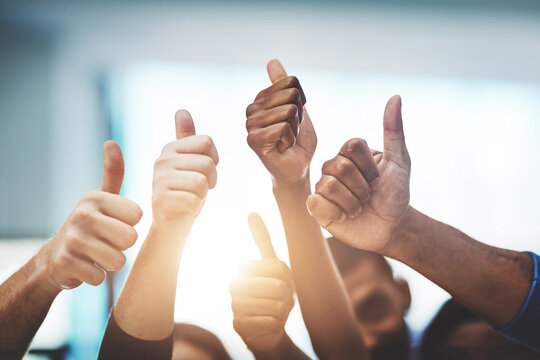 Keep up the amazing work. Cropped shot of a team of colleagues showing thumbs up at work.
