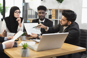 Team of diverse competent financiers showing graphs and charts on laptop during video conference. Company workers having online call with director or colleagues at office.