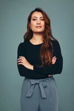 Self-confident young woman standing alone in a studio