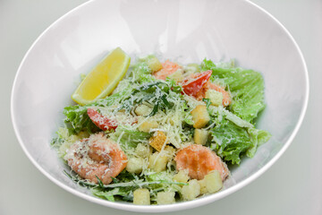 light dietary salad of leaves, red fish fillet, grated cheese croutons and dressing. The theme of proper and healthy nutrition, diet and weight loss