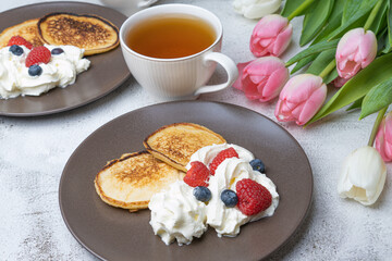 Sweet homemade pancakes with blueberries and strawberries jam and sour cream. tea on a white background, view from the top. The concept of breakfast, snacks and nutrition. Maslenitsa.